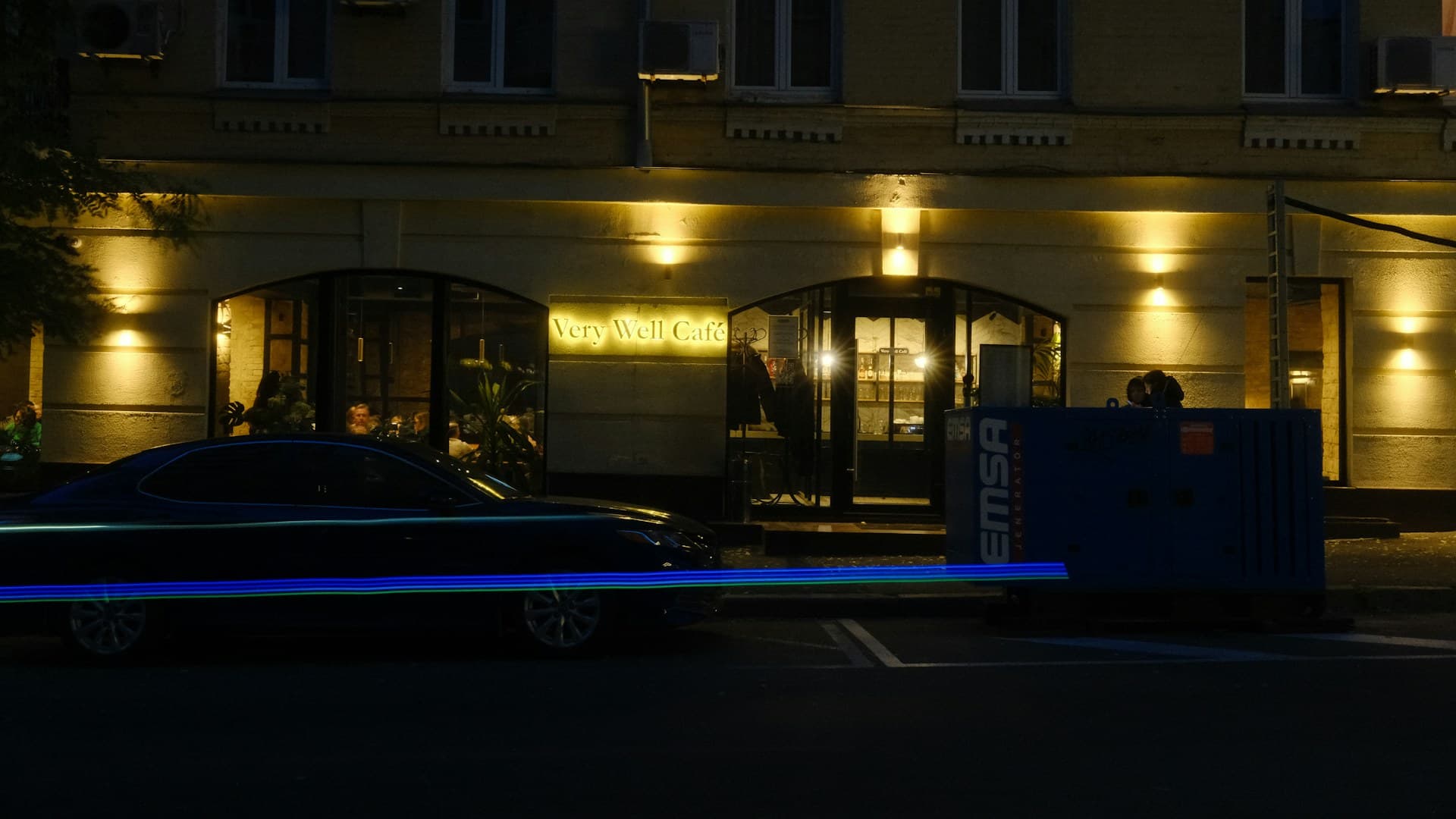 Dark saloon waiting outside a warmly lit hotel entrance at night